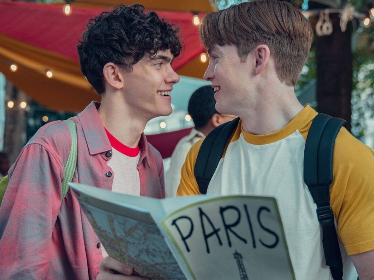 Dos personas sonríen y se miran mientras una de ellas sostiene un mapa de París