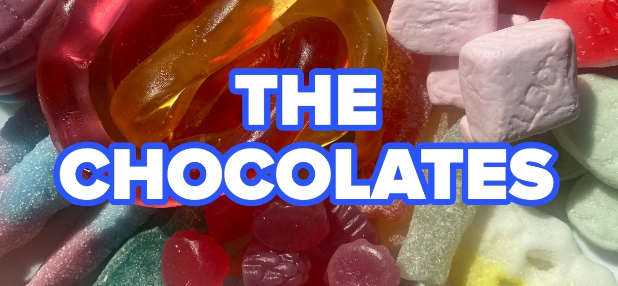 An assortment of colorful candies with the text &quot;THE CHOCOLATES&quot; prominently in the center
