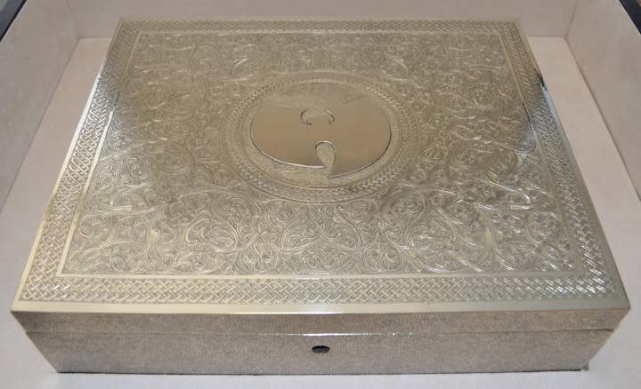 An intricately designed metal box featuring the Wu-Tang Clan's logo on its lid
