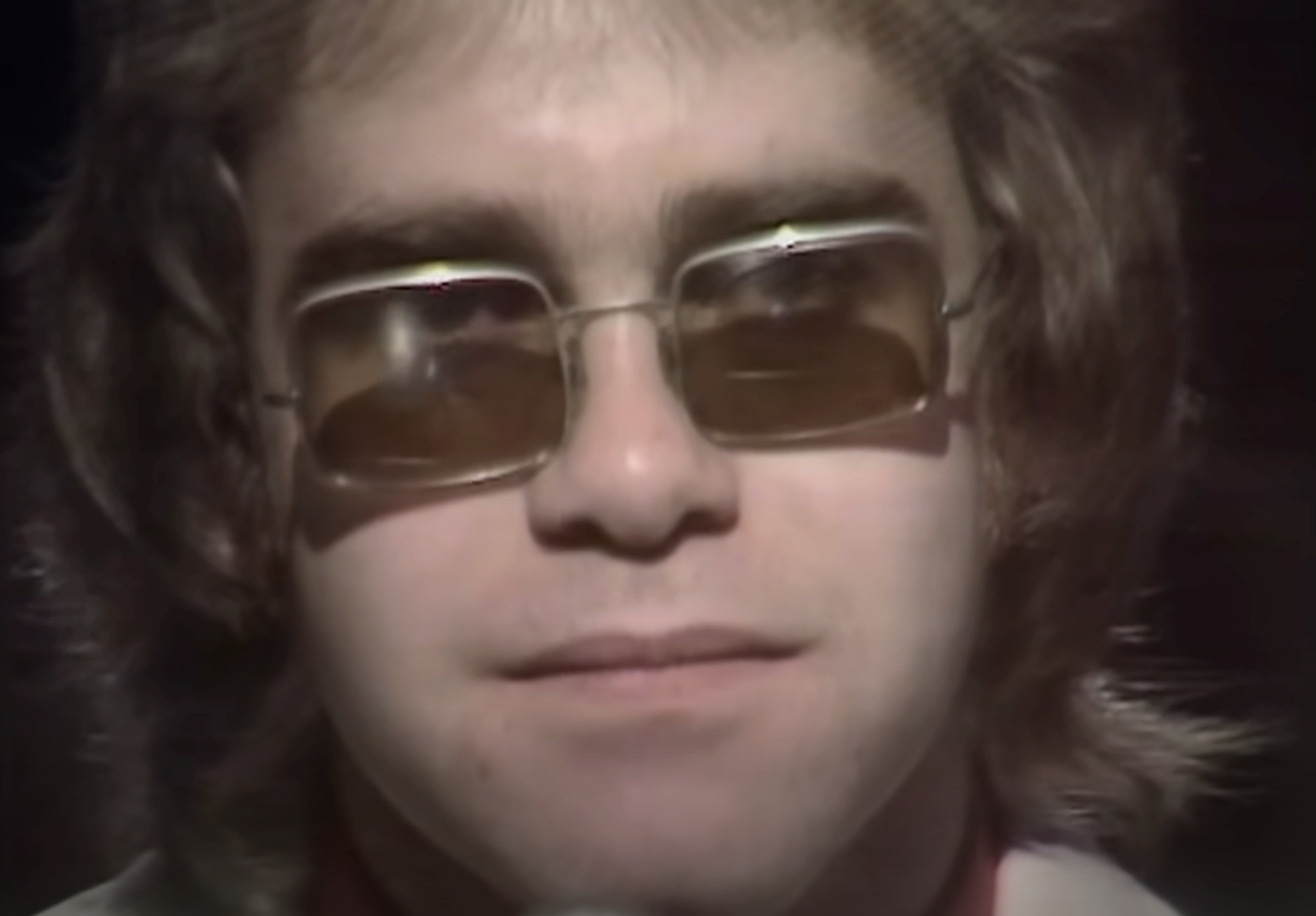 Elton John in close-up wearing tinted glasses