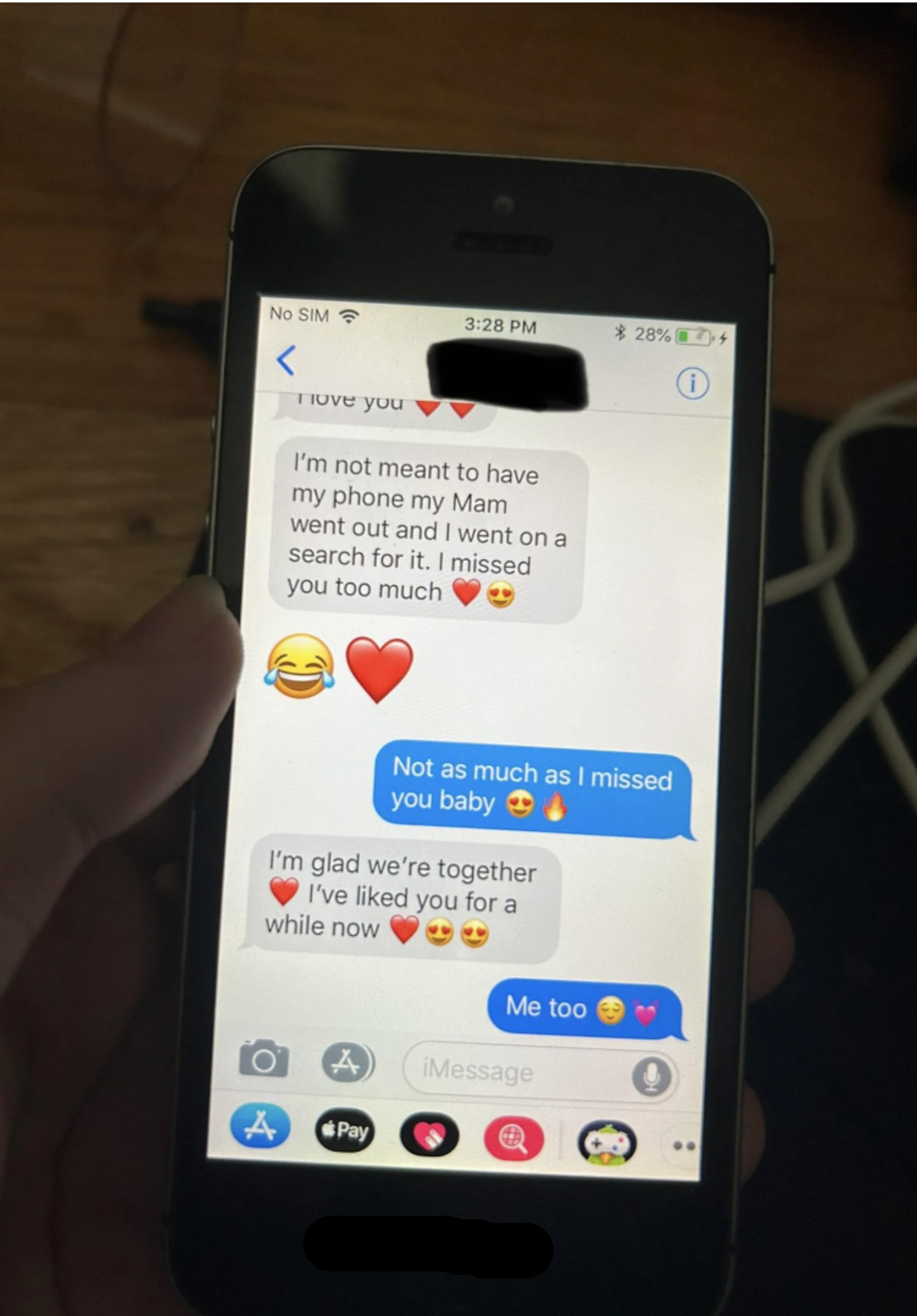 Close-up of a phone screen showing a text conversation about missing each other and expressing affection using emojis