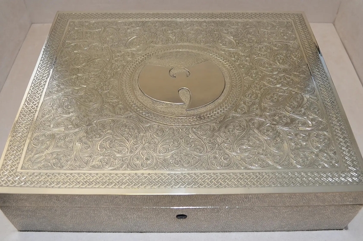 An intricately designed metal box featuring the Wu-Tang Clan's logo on its lid
