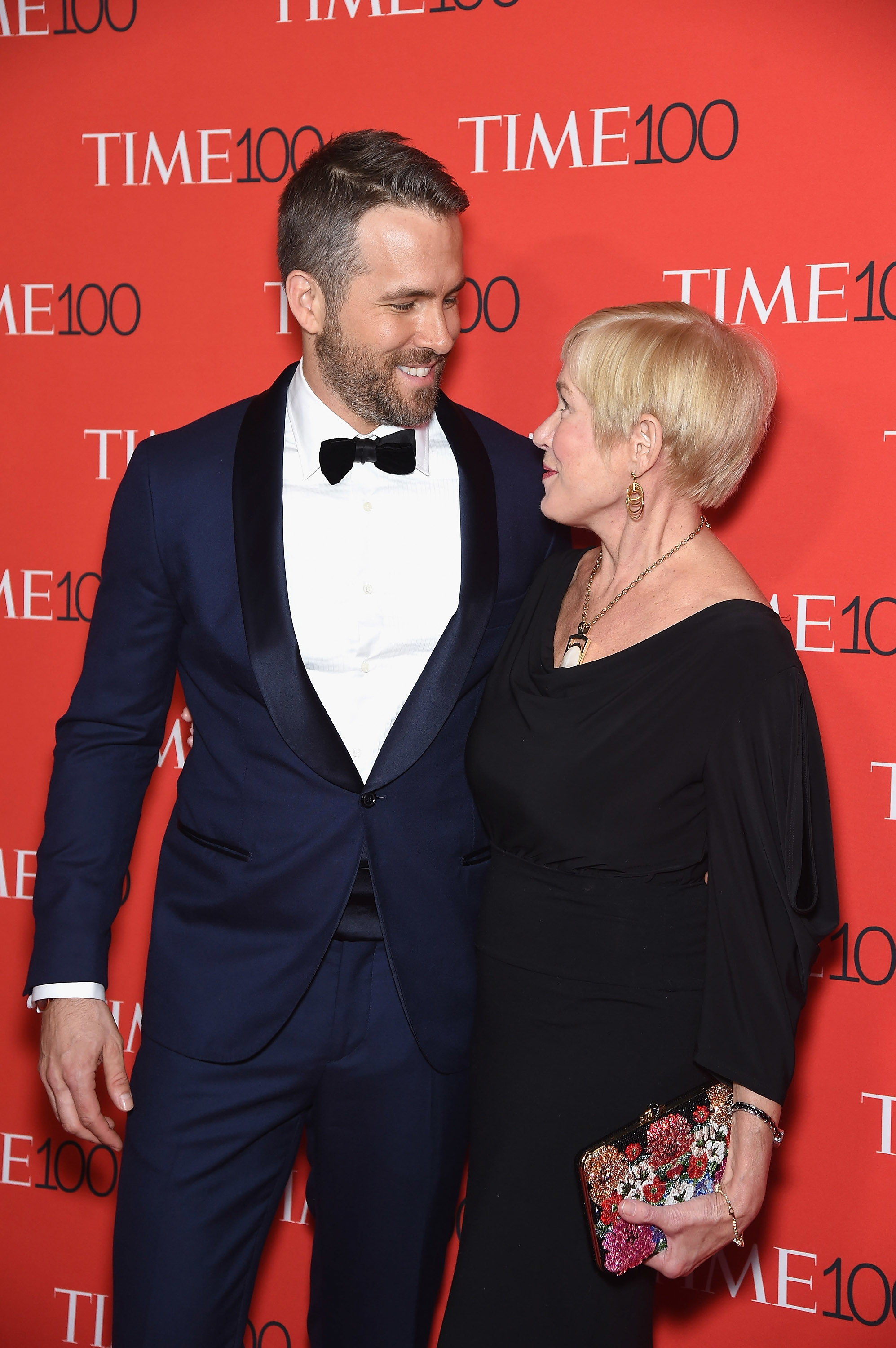 Ryan Reynolds in a tuxedo stands on the red carpet with Tammy Reynolds in a black dress at the TIME 100 event