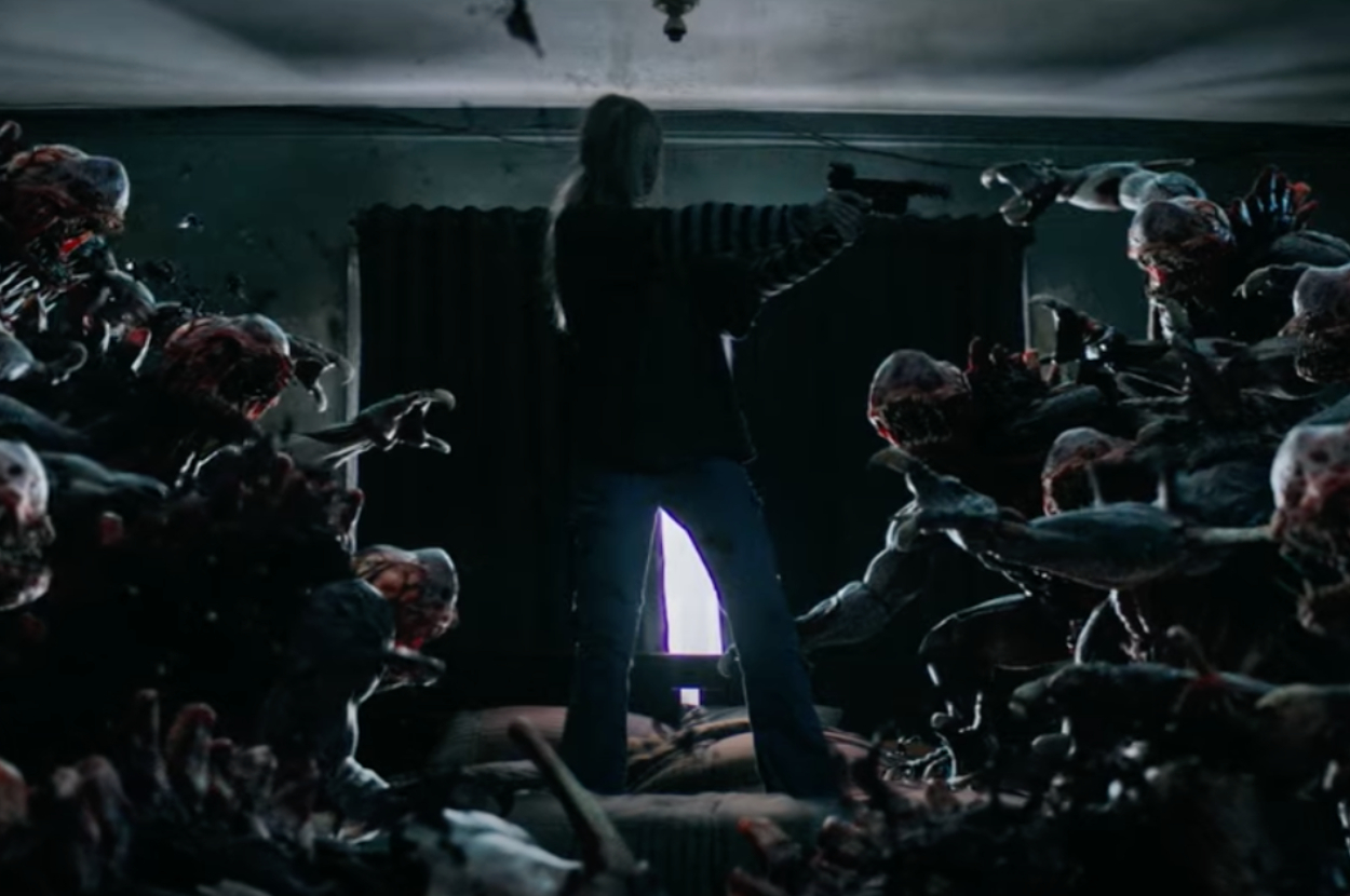 Person stands ready to fight numerous monstrous creatures in a dark room, with a light source behind them casting shadows and creating an intense atmosphere