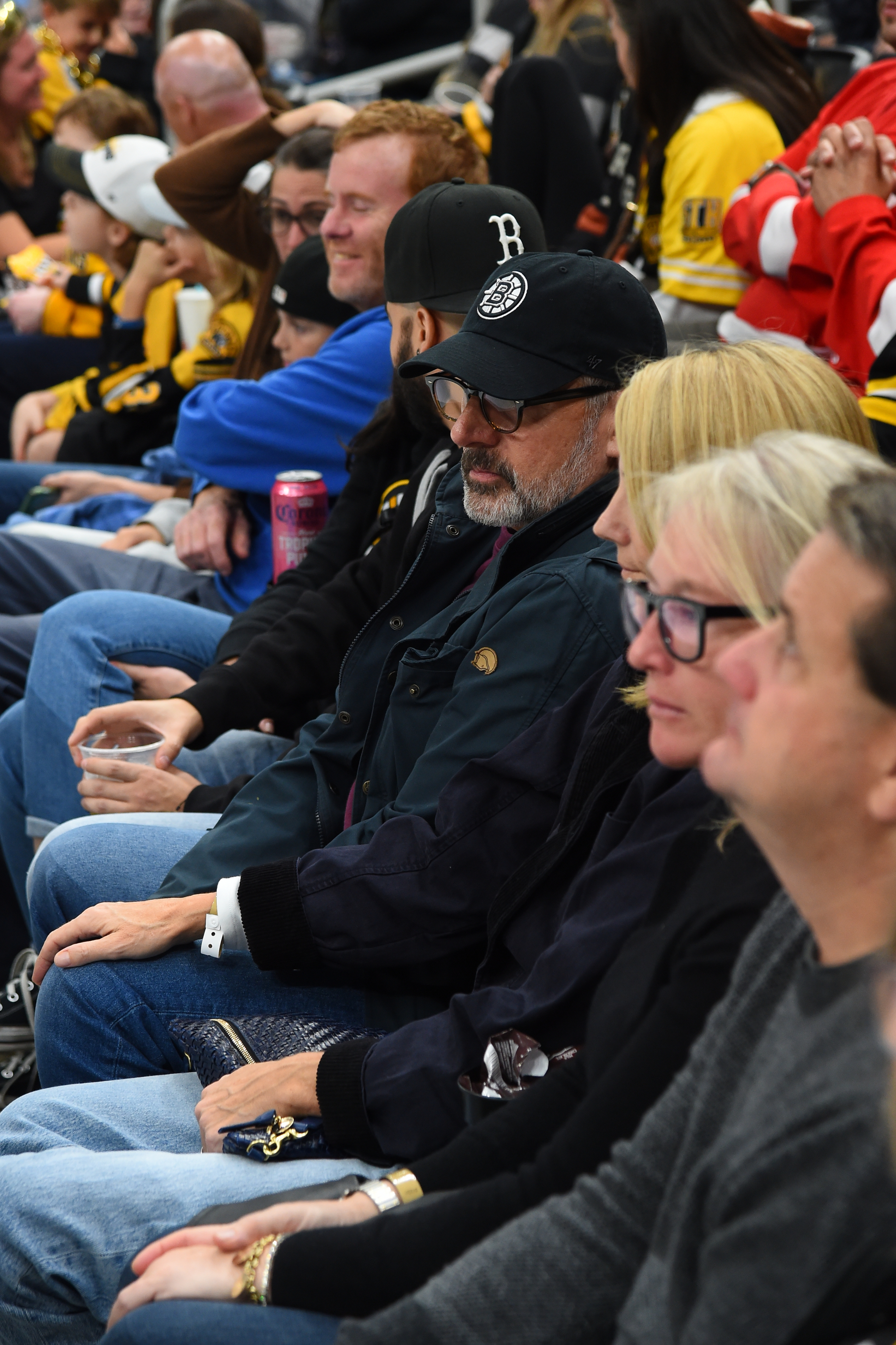 A group of people sitting in the stands at a sports event, intently watching the game