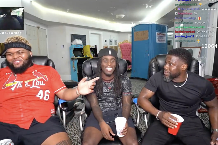 From left to right, Duke Dennis, Kai Cenat, and Kevin Hart are sitting together in a lively room, smiling and chatting