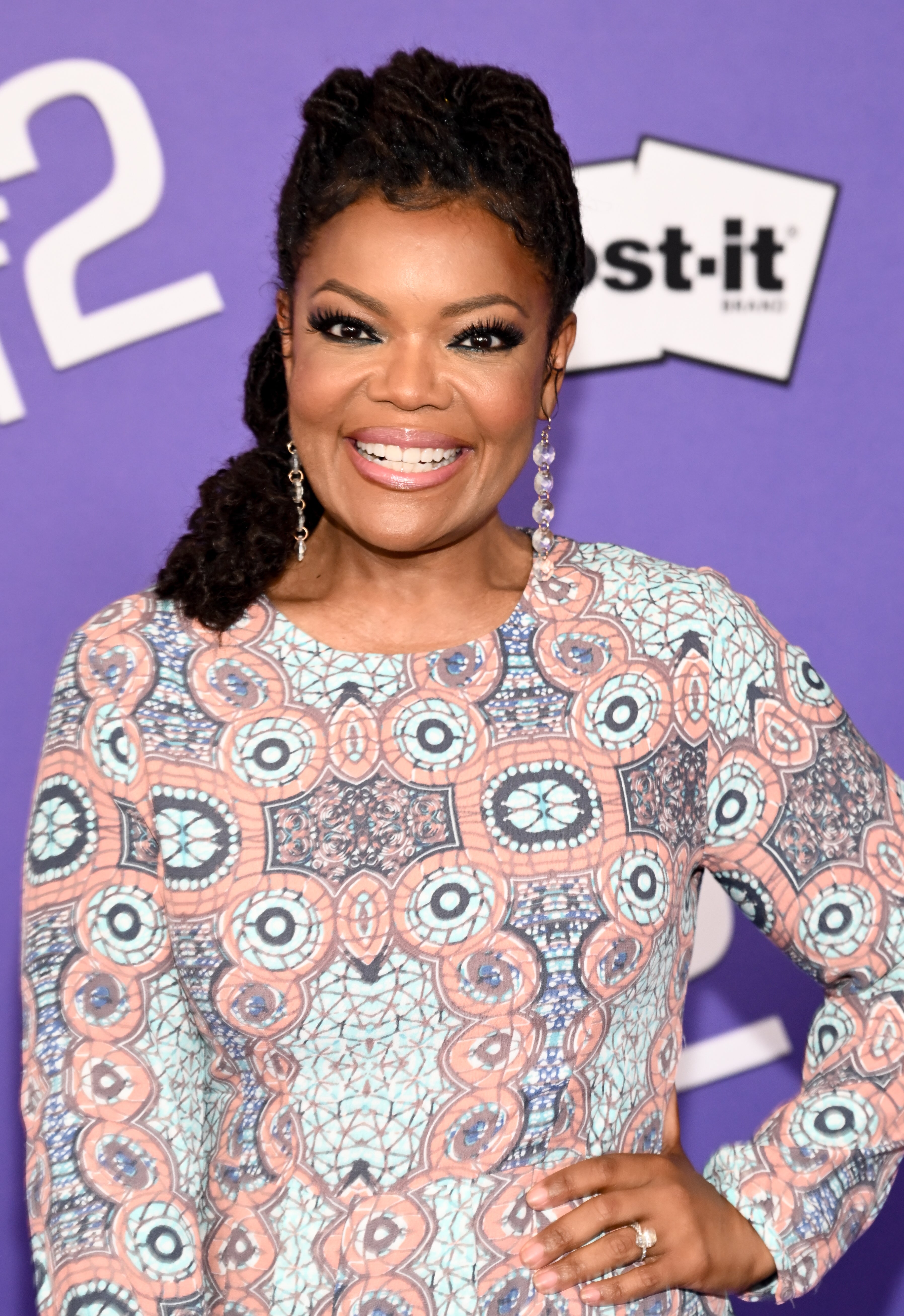 Yvette Nicole Brown smiles in an intricately patterned dress with her hand on her hip at the premiere of &quot;Inside Out 2&quot;