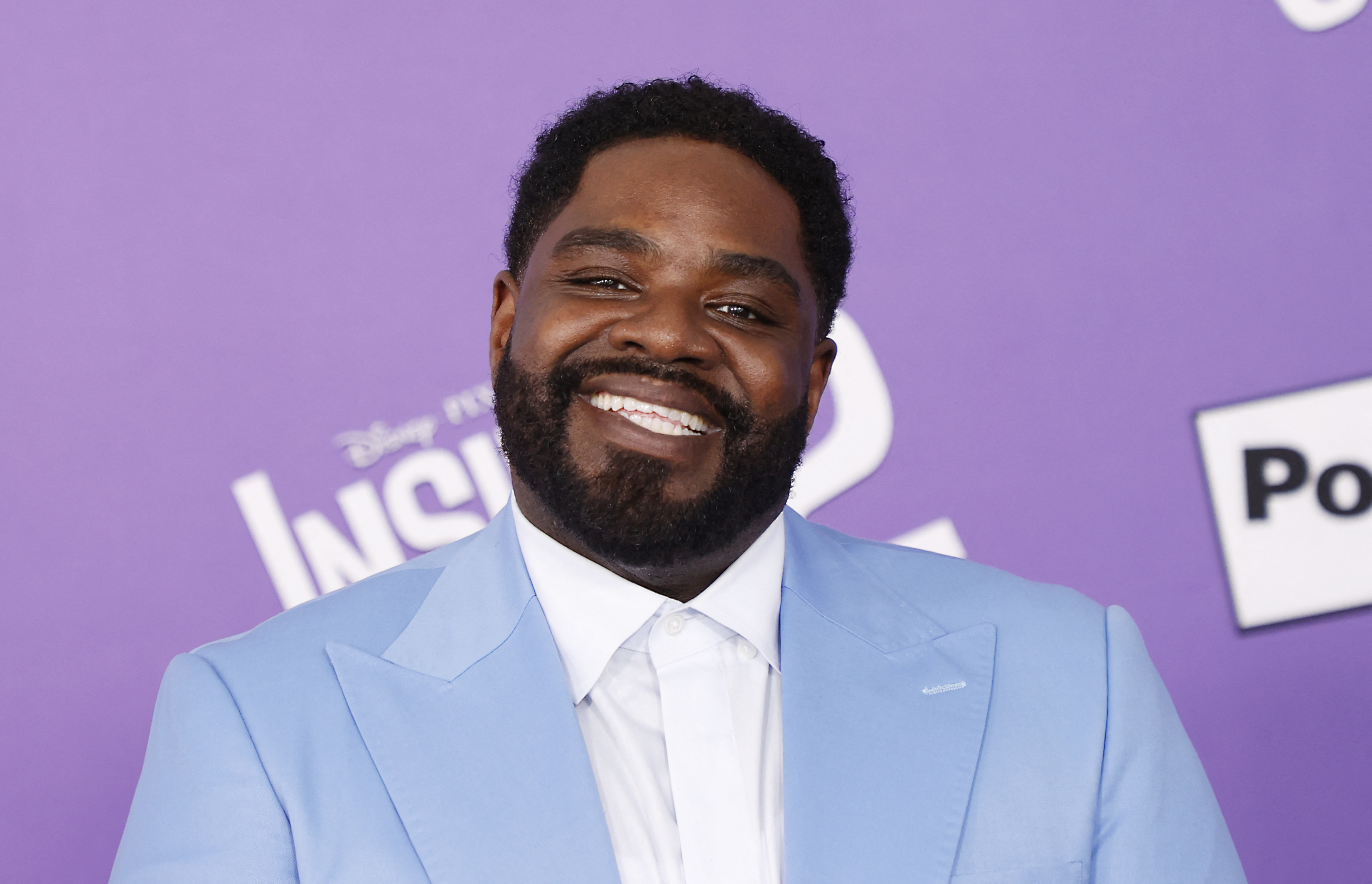 Ron Funches wearing a light-colored suit and white shirt at the premiere of &quot;Inside Out 2&quot;