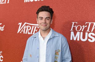 Cody Ko stands on a red carpet wearing a light blue jacket over a white shirt at a Variety event