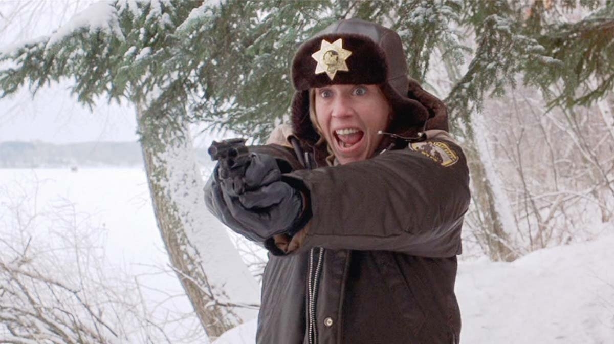 A police officer with a badge on their fur hat points a gun, appearing alarmed, in a snowy outdoor setting