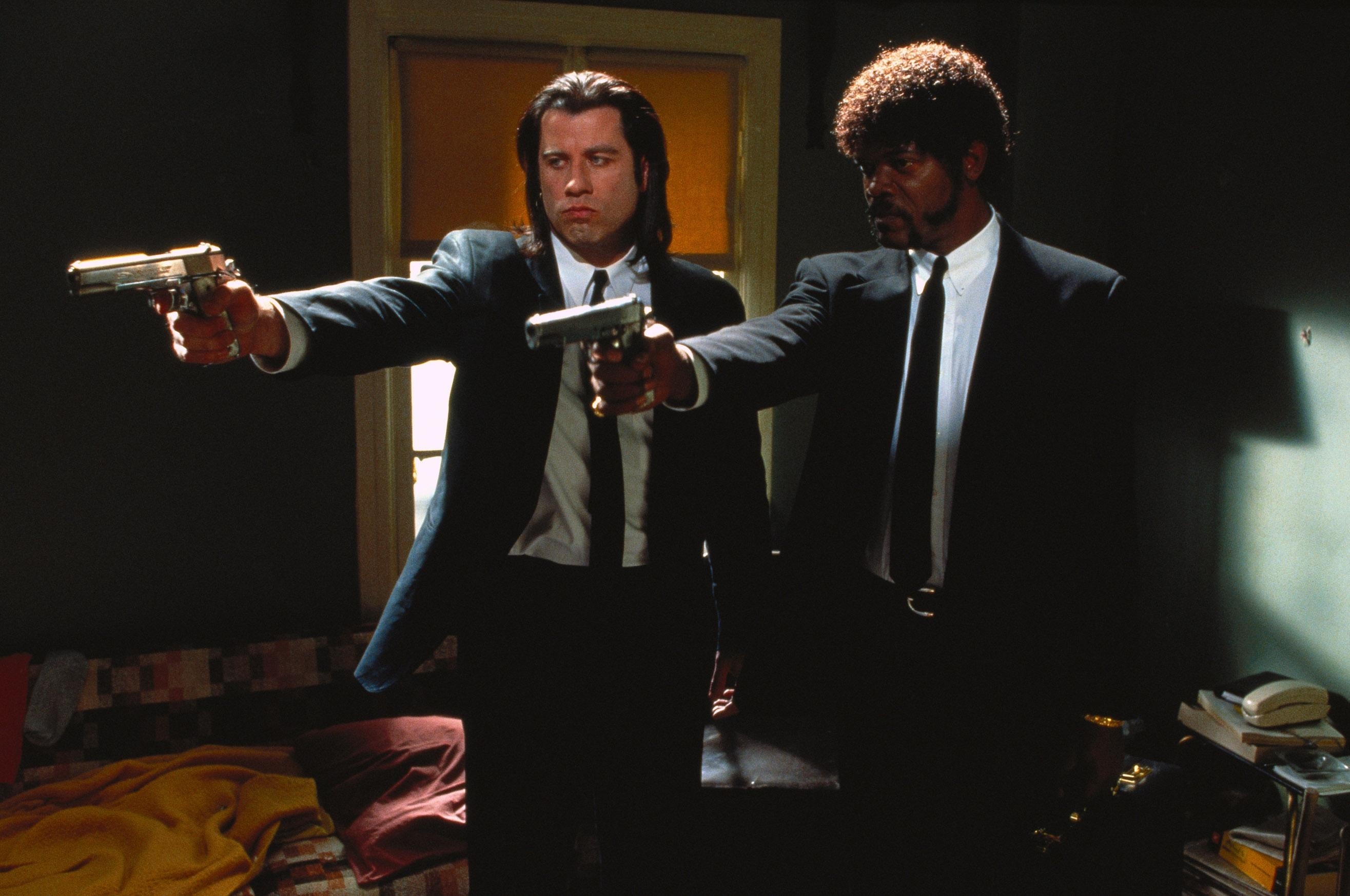 John Travolta and Samuel L. Jackson in a scene from "Pulp Fiction," wearing suits and pointing guns