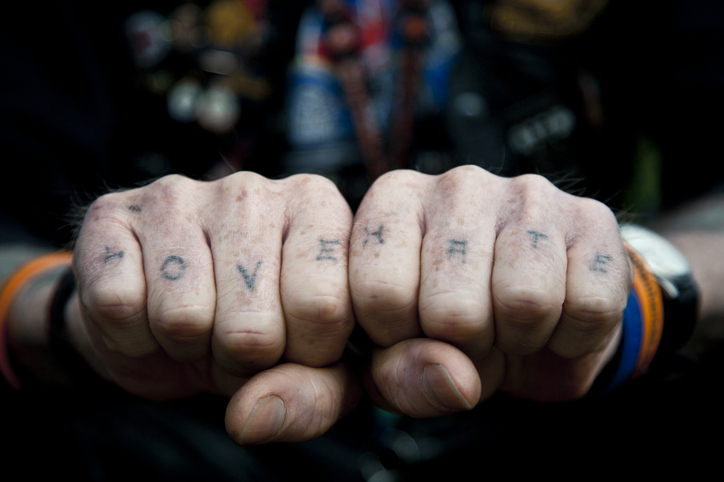 Close-up of a person's knuckles with tattoos reading &quot;LOVE&quot; on the left hand and &quot;HATE&quot; on the right hand