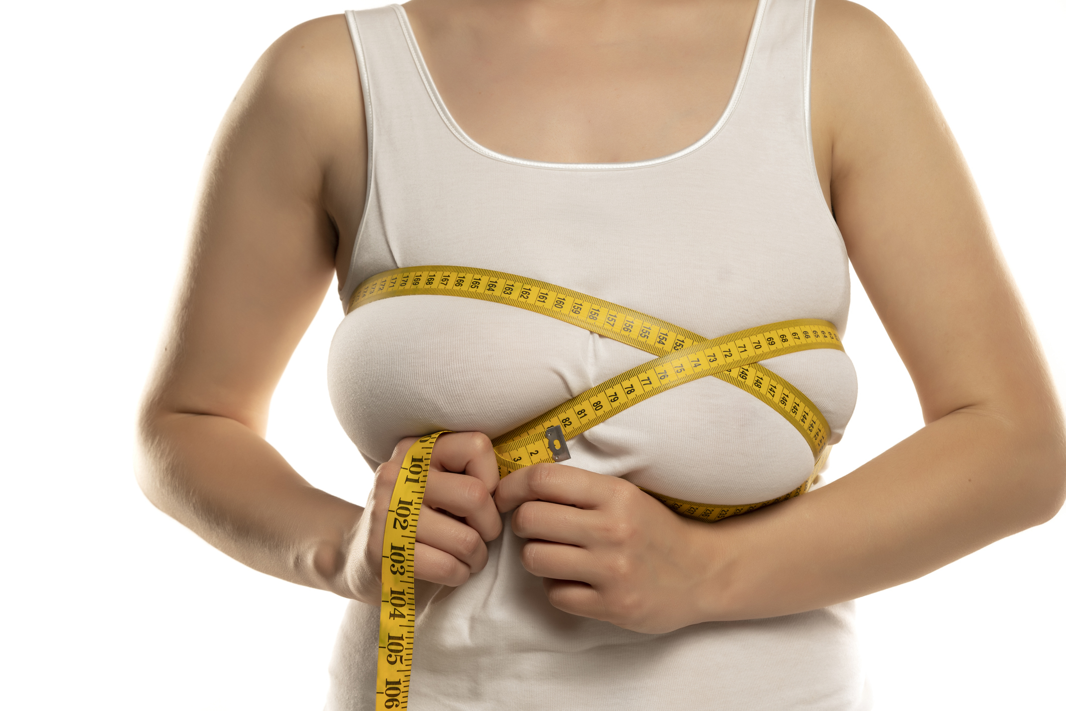 A person in a white tank top measures their chest with a yellow measuring tape