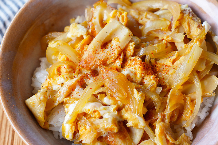 どんぶりに盛られたご飯の上に、炒めた玉ねぎと卵が載っている料理の写真。