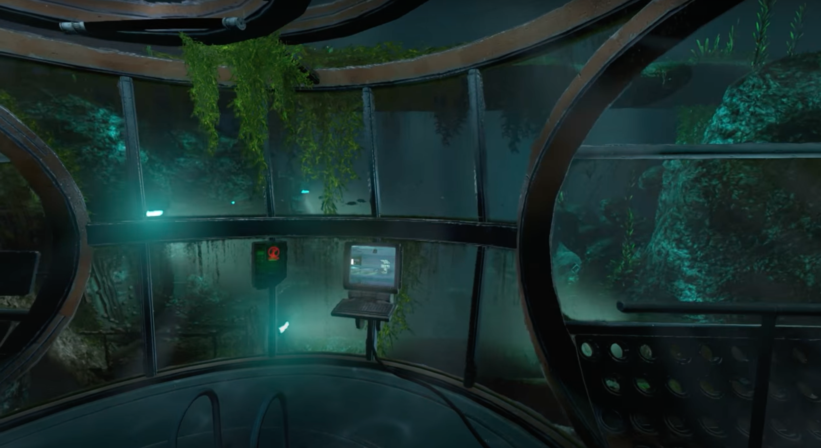 Underwater laboratory with a circular window view of aquatic plants and rock formations. A laptop is positioned on a console inside