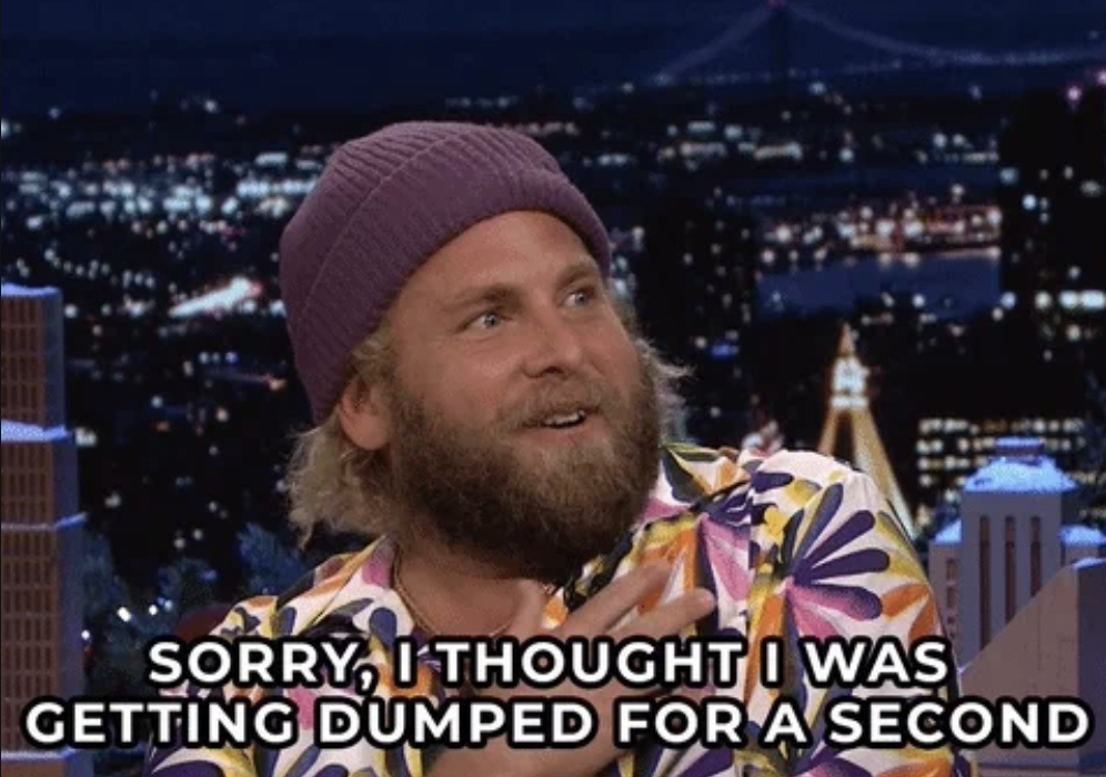 Jonah Hill in a colorful patterned shirt and a beanie is on a late-night talk show set with city lights in the background. Text reads: "SORRY, I THOUGHT I WAS GETTING DUMPED FOR A SECOND."
