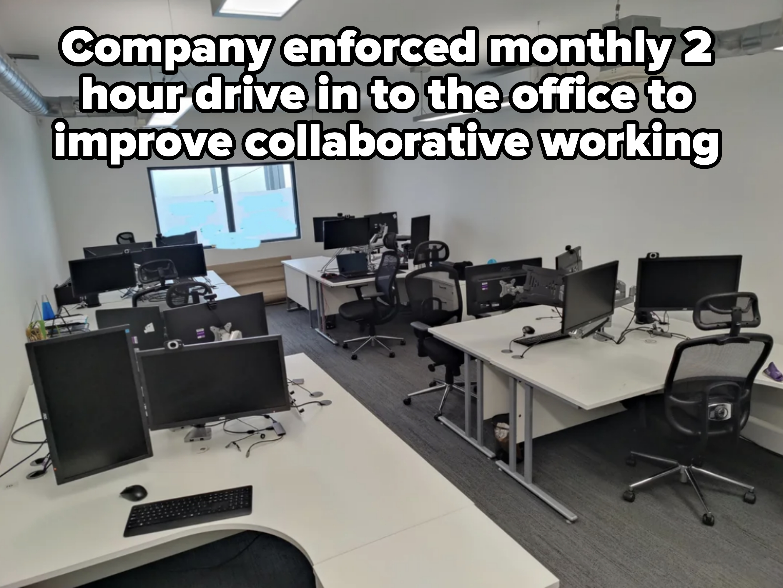 Empty office space with multiple desks and computer monitors, no people present