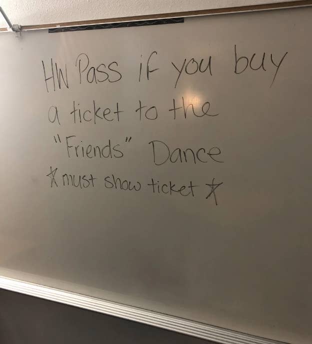 Whiteboard message offering a homework pass for buying a "Friends" Dance ticket, with a note: "must show ticket."