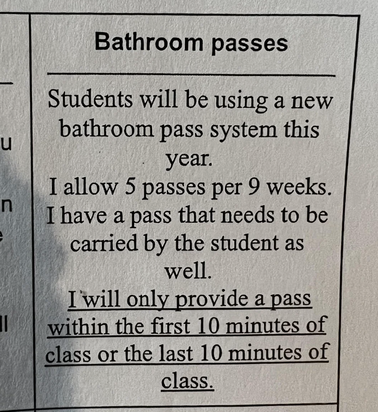 Sign explaining new bathroom pass rules: 5 passes per 9 weeks, students carry pass, provided only in the first and last 10 minutes of class
