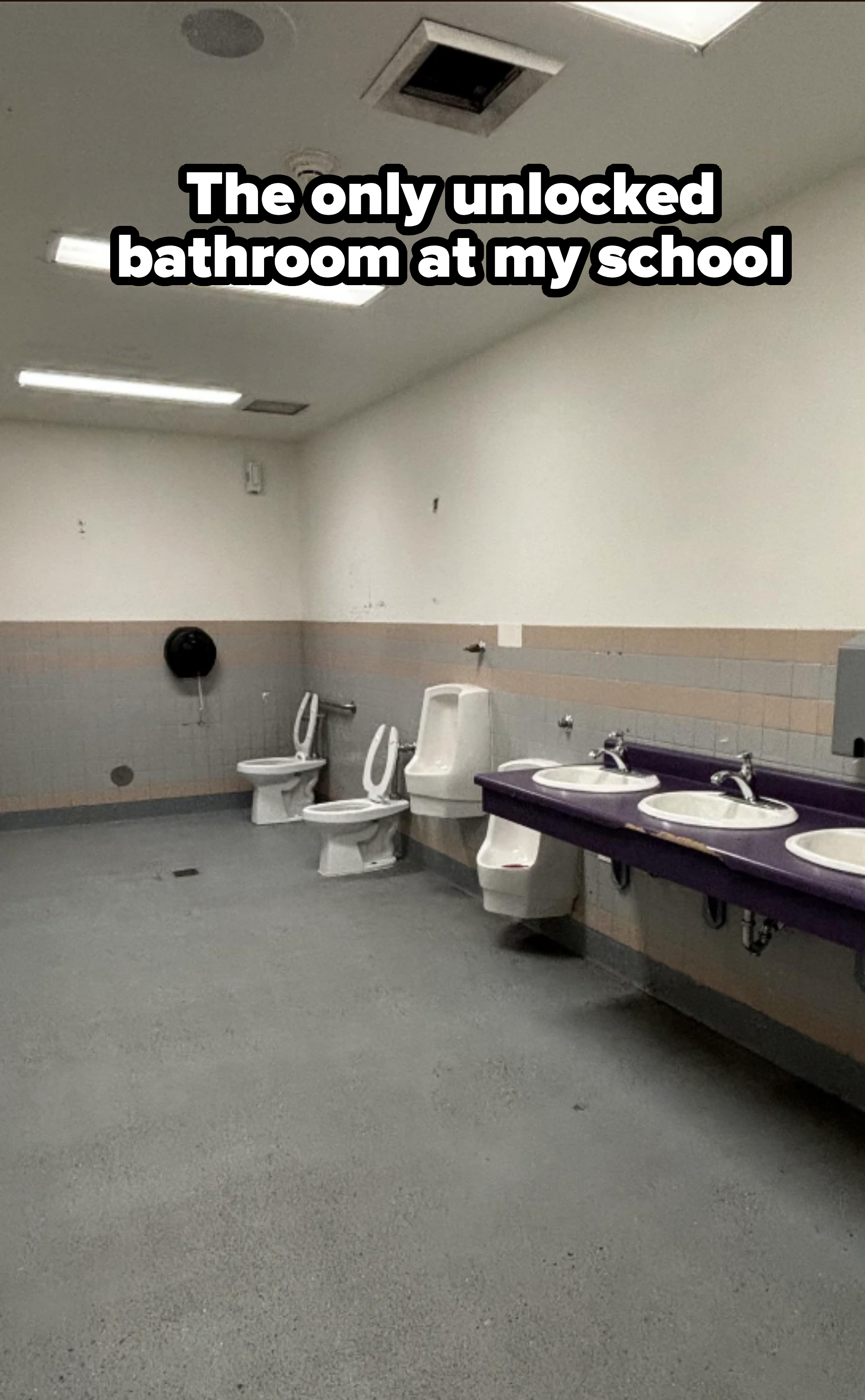 Public restroom with two toilets, a urinal, and a vanity with three sinks. The room is clean and brightly lit