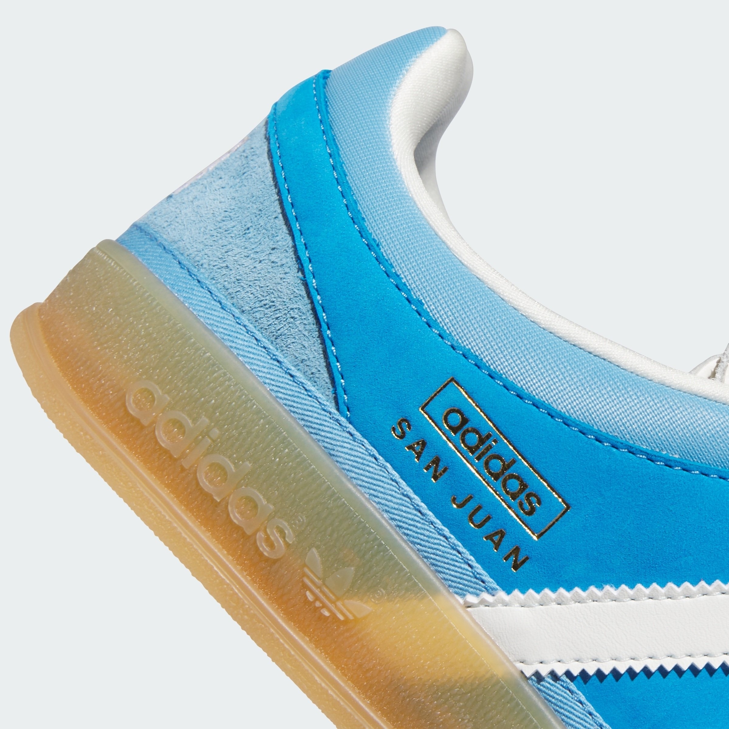Adidas San Juan sneaker close-up, featuring a translucent sole and white stripes on the side with &quot;San Juan&quot; text