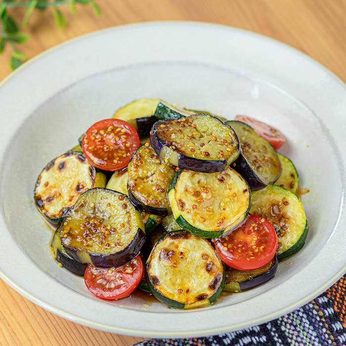 グリルしたナス、ズッキーニ、トマトのスライスを盛り付けた皿。