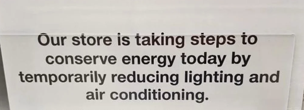 Sign reading, "Our store is taking steps to conserve energy today by temporarily reducing lighting and air conditioning."