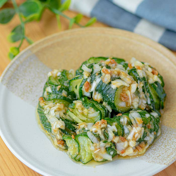 おいしそうなきゅうりとねぎの和え物が白い皿に盛られている。