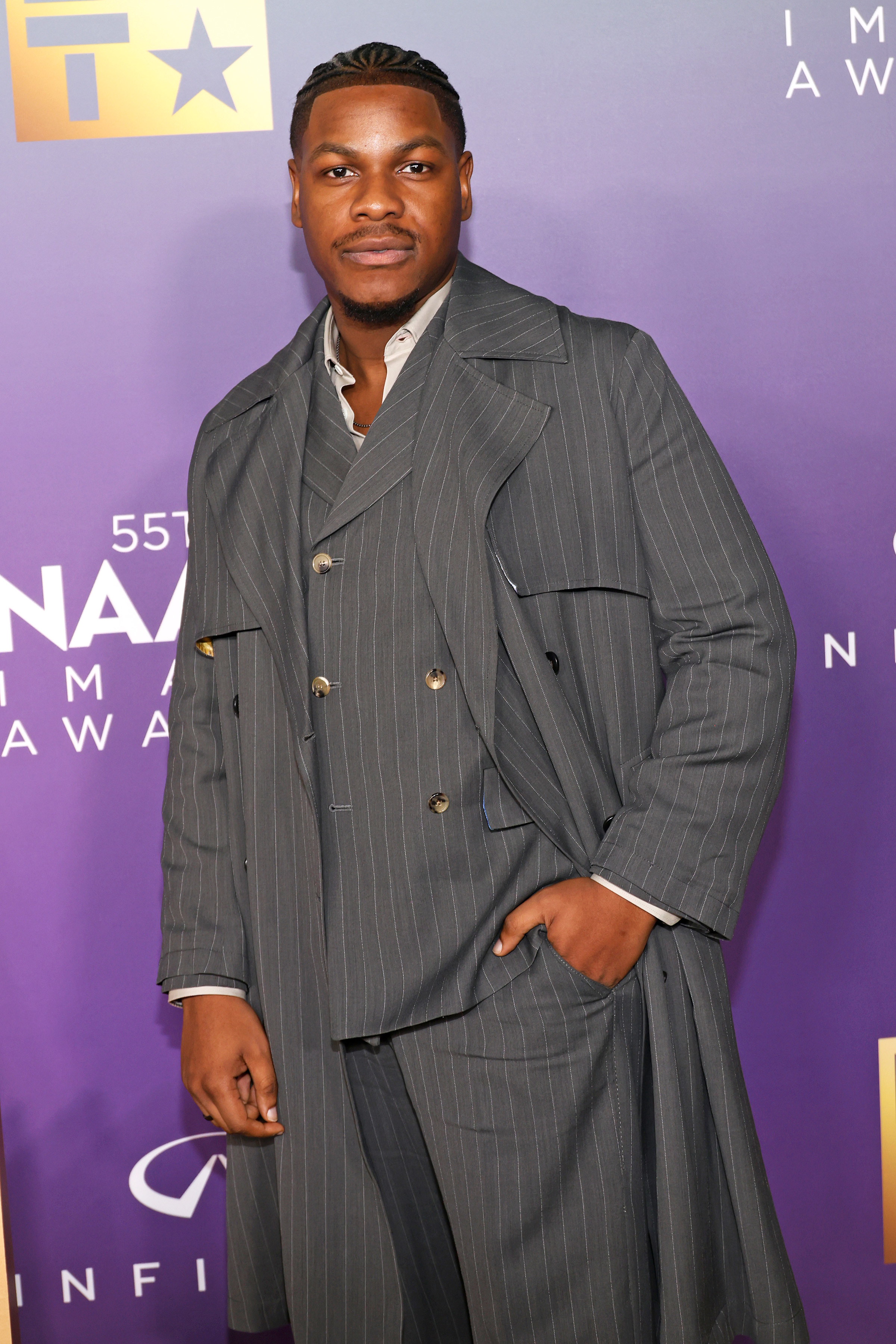 John Boyega in a pinstripe suit and trench coat at the 55th NAACP Image Awards