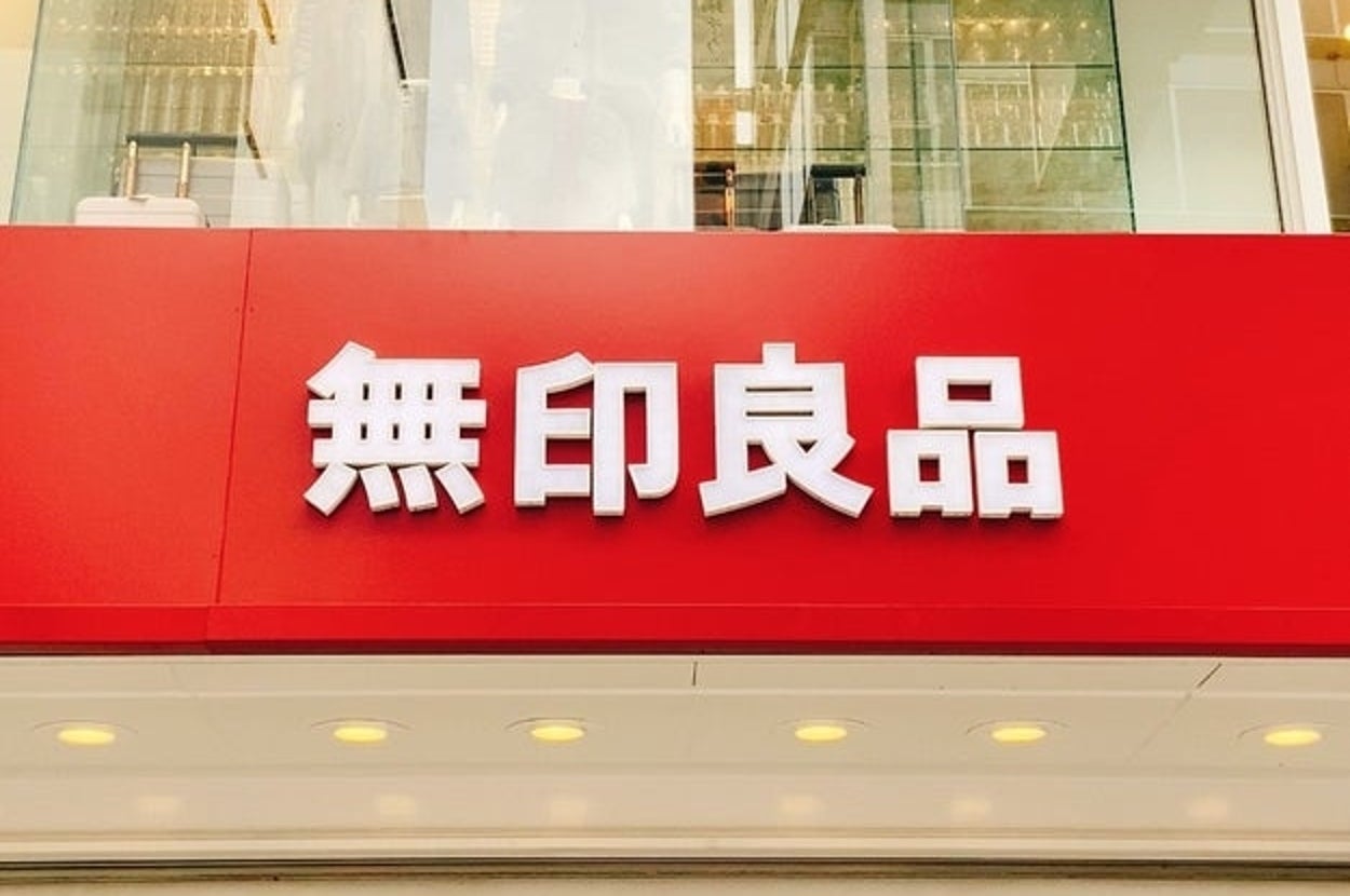 赤い看板に「無印良品」と書かれた店舗の外観。
