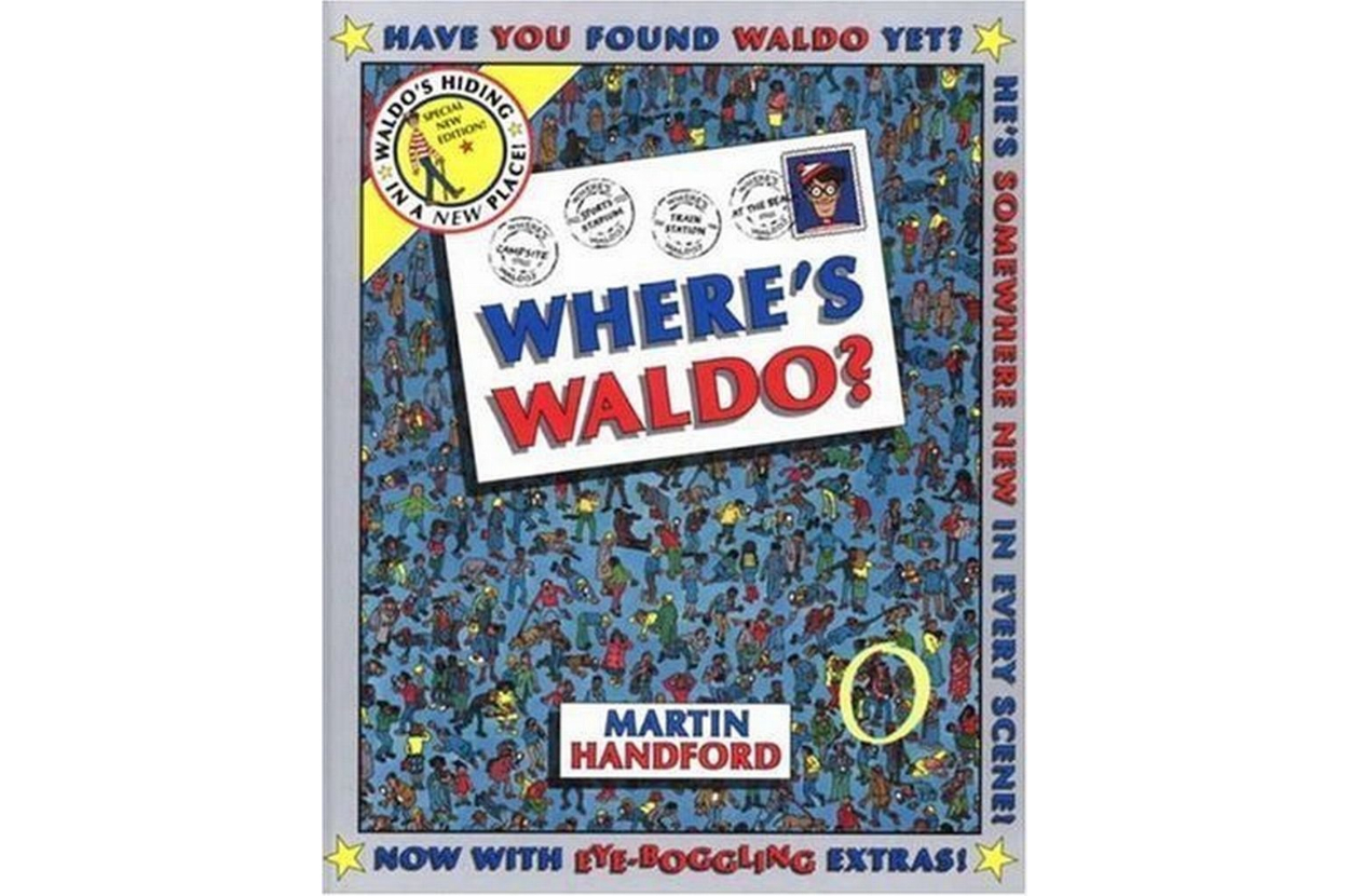 Cover of the book &quot;Where's Waldo?&quot; by Martin Handford, showing a busy crowd scene with Waldo hidden among them. The text: &quot;Have you found Waldo yet?&quot; and &quot;Now with eye-boggling extras!&quot;