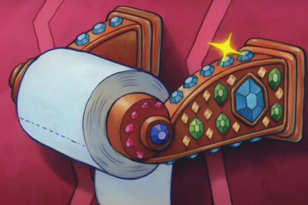 An ornate toilet paper holder adorned with colorful gemstone decorations, with a sparkling star above one of the jewels