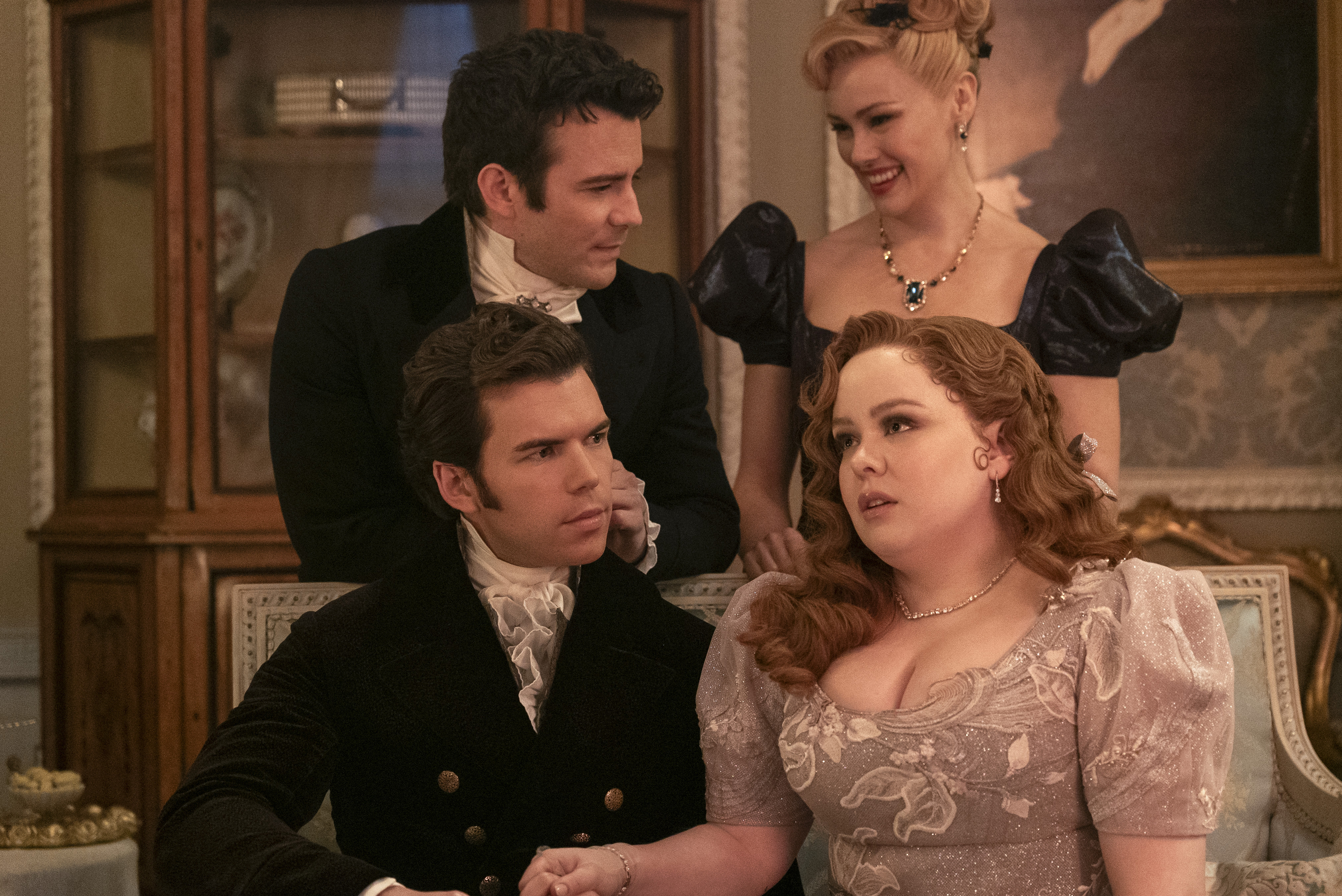 Luke Thompson, Jonathan Bailey, Nicola Coughlan, and Polly Walker in period costumes, posing together in an elegant, vintage-style room