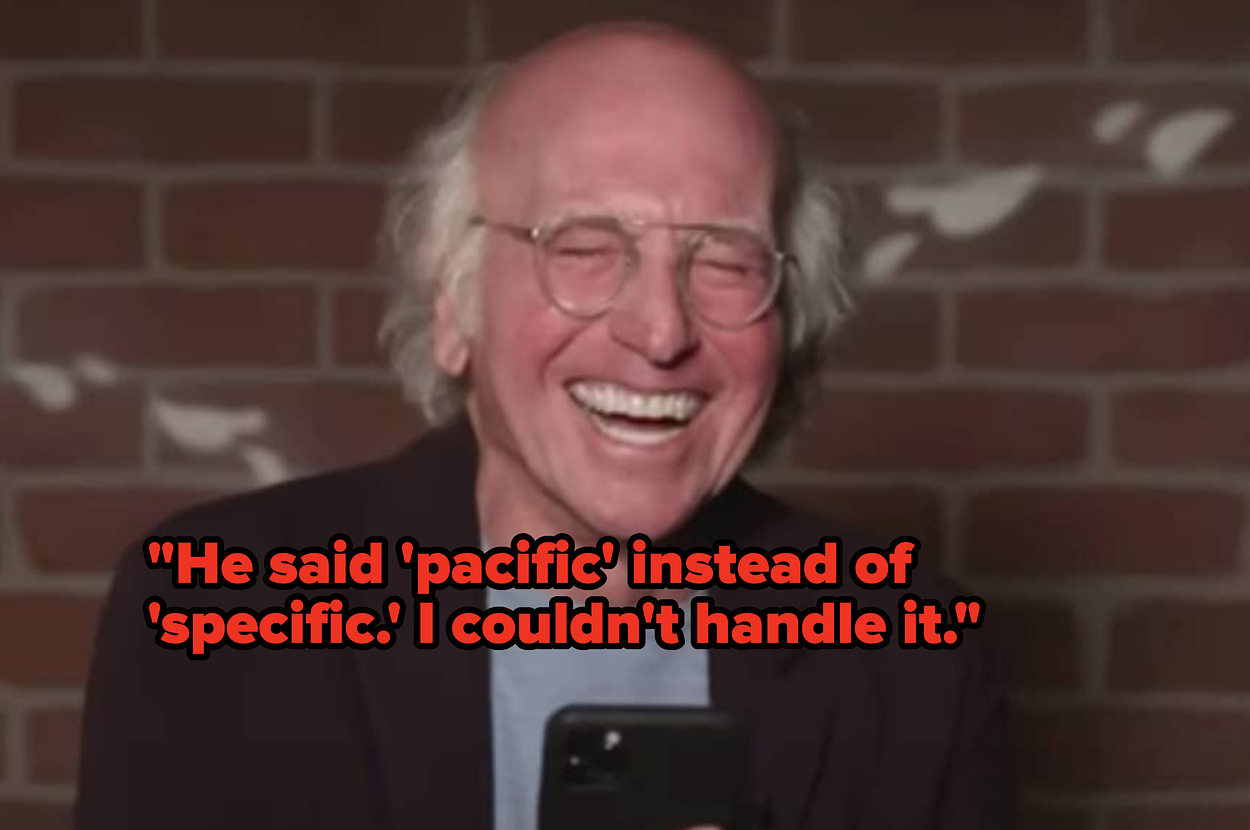 Megan Thee Stallion on a talk show set, wearing a red blouse, gold hoop earrings, and bracelets, with a surprised expression and hands raised