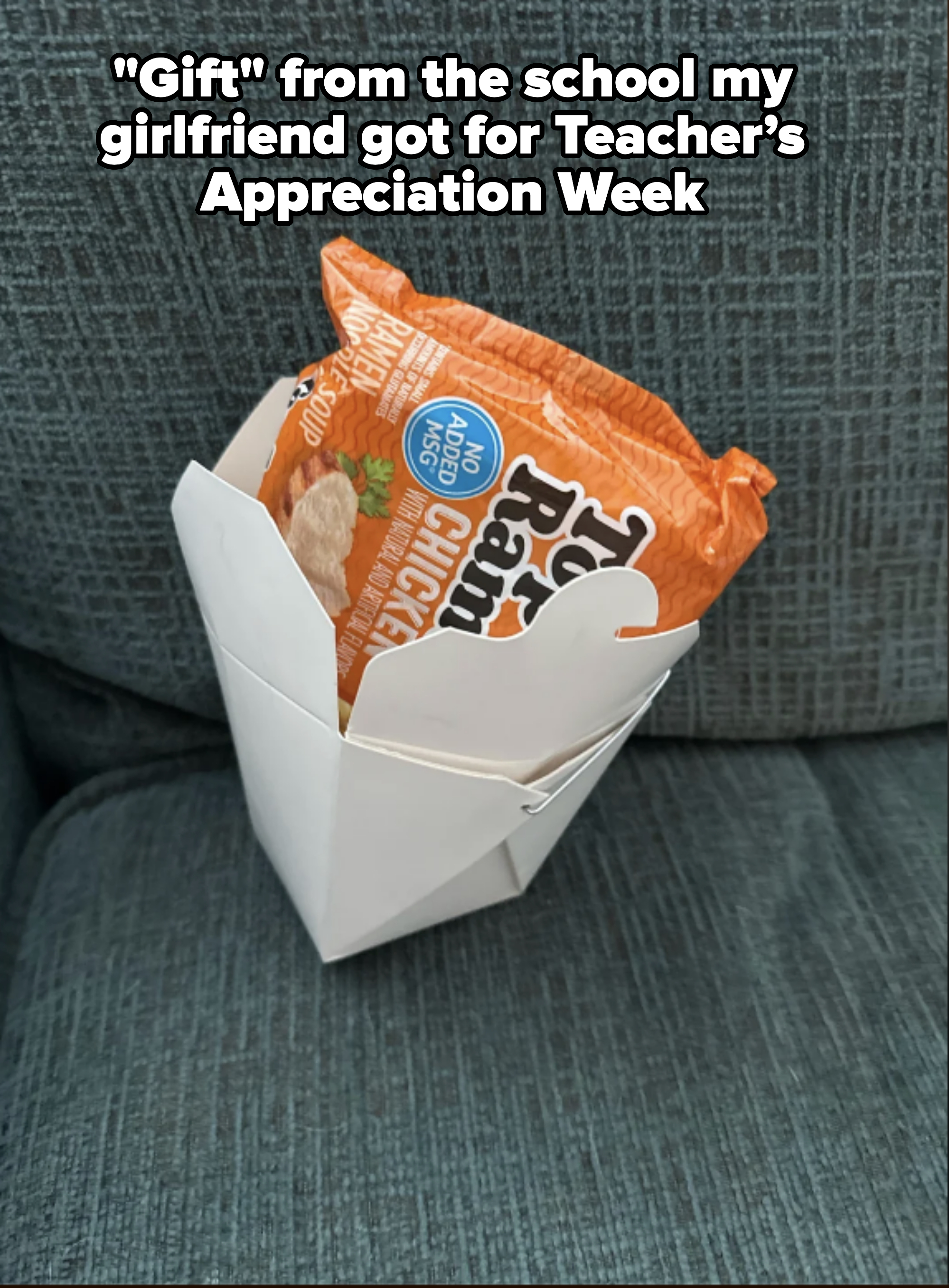 Top Ramen chicken noodle packet inside a white takeout container on a couch