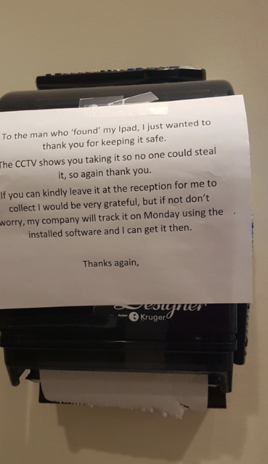 Note left on a paper towel dispenser thanking someone for finding an iPad and asking for it to be returned to reception. Mentions CCTV footage and recovery plan
