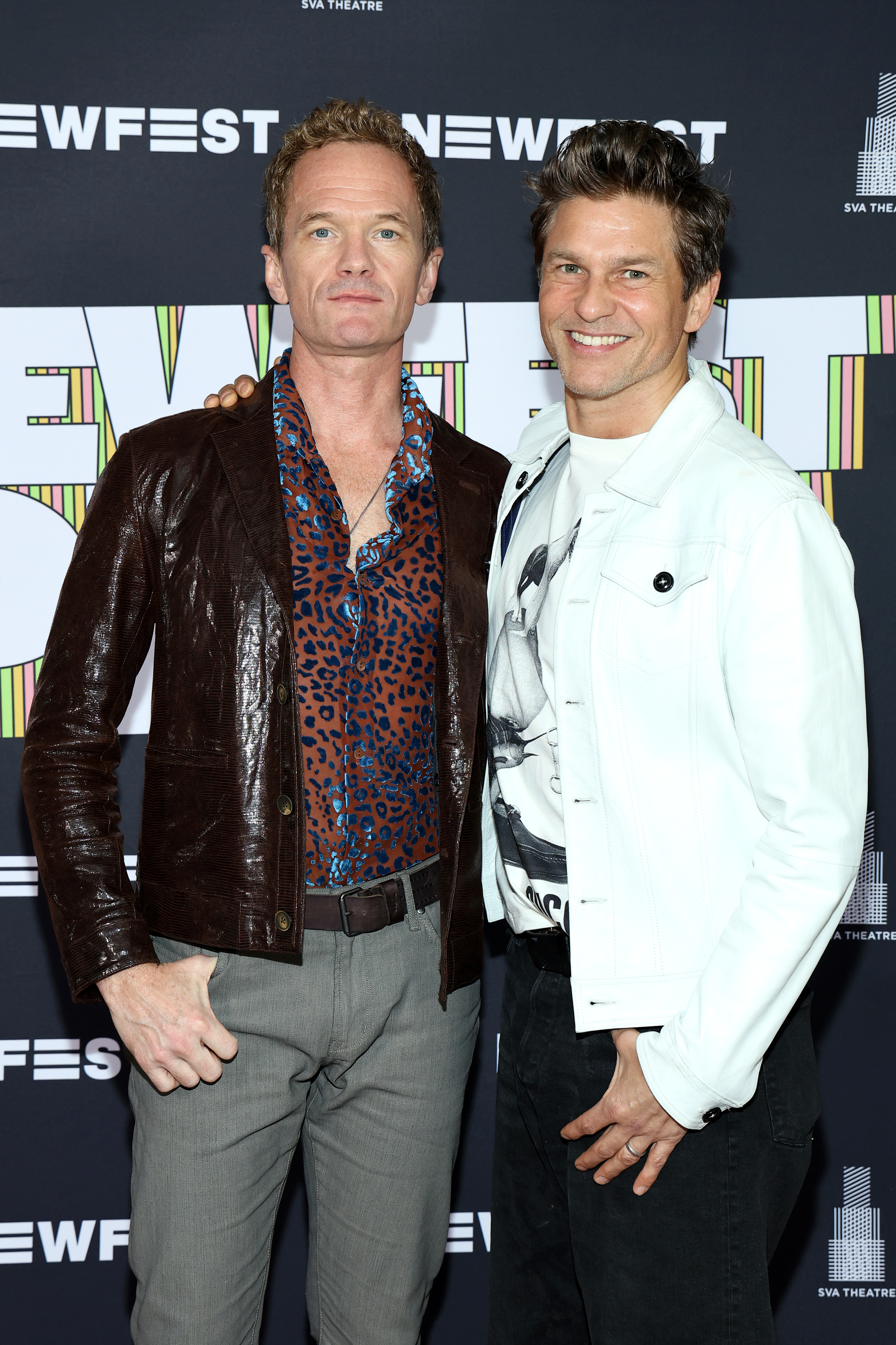 Neil Patrick Harris in a patterned shirt and leather jacket, with David Burtka in a white jacket, at NewFest at SVA Theatre