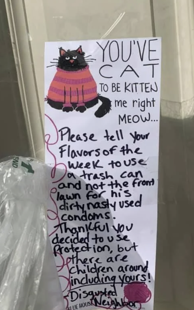 Handwritten note on a door about proper disposal of used condoms, mentioning children are around. It has a drawing of a cat in a pink sweater at the top