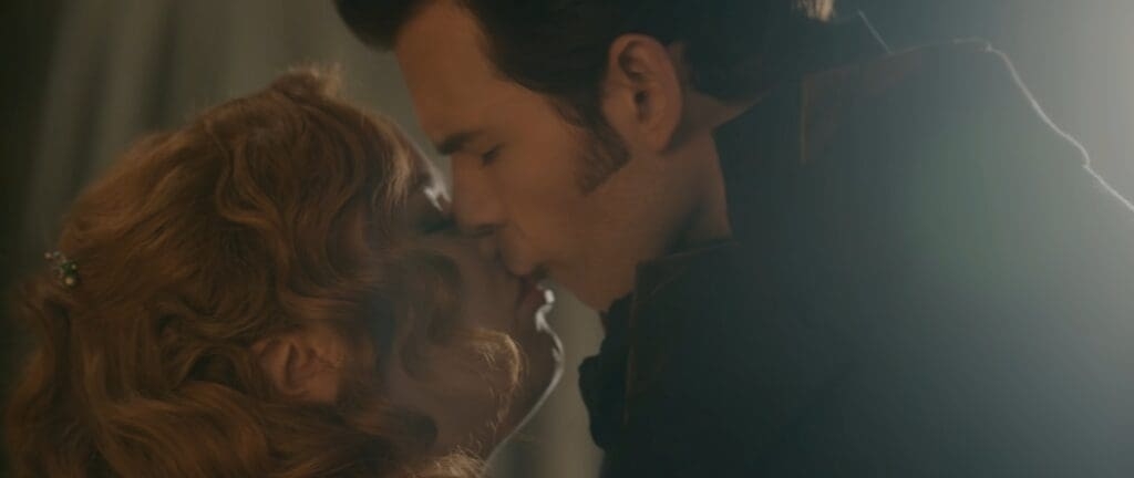 Jessica Chastain y Chris Hemsworth se besan en una escena de una película, ambos vestidos con ropa de época