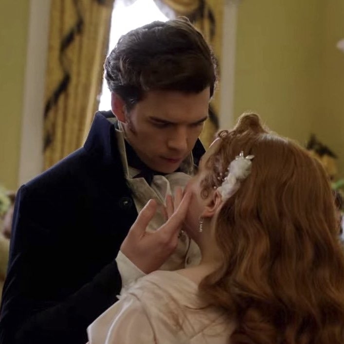 Nicola Coughlan y Luke Newton en una escena romántica de la serie Bridgerton, con trajes de época del siglo XIX