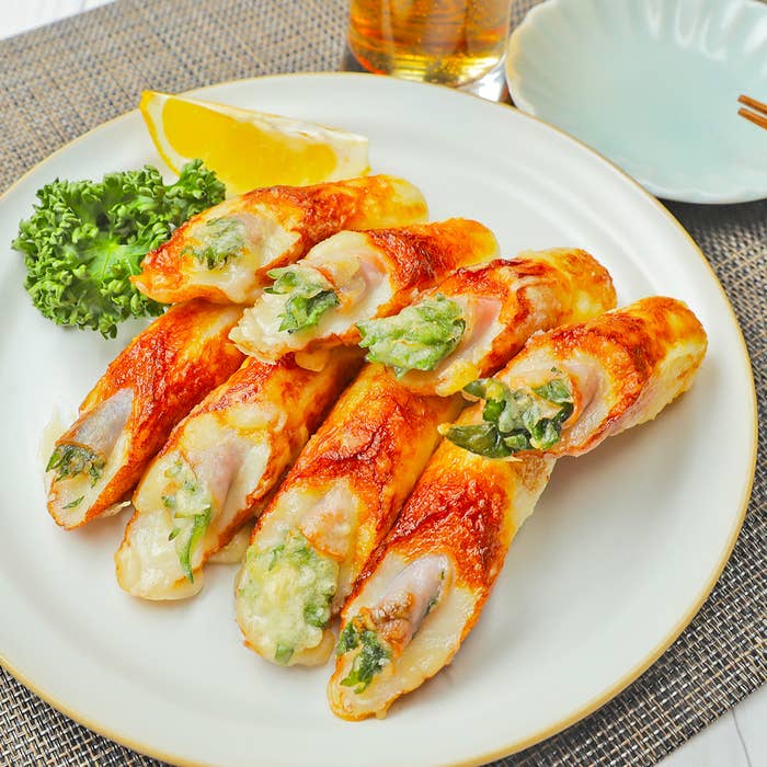 お皿に並べられた数本の野菜を詰めたちくわ、レモンのくさび型スライスとパセリが添えられている。