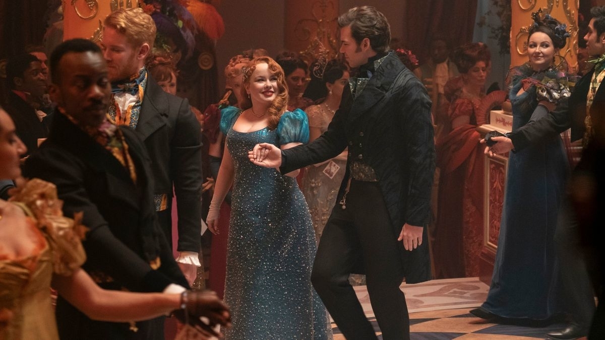 Personajes de la serie "Bridgerton" en un baile formal. Los hombres llevan trajes elegantes y las mujeres, vestidos de época glamurosos