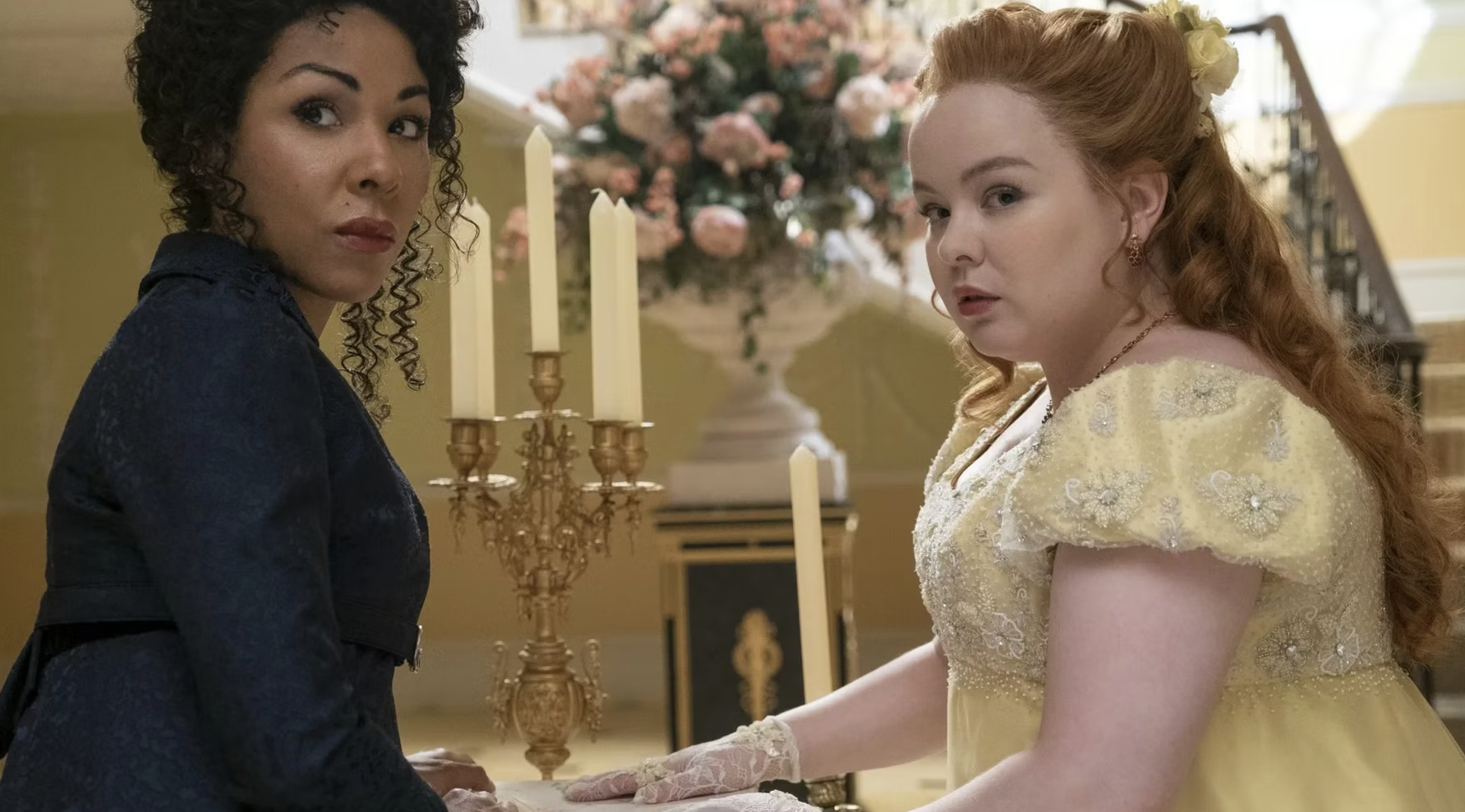 Charithra Chandran y Nicola Coughlan en una escena de época de Bridgerton, ambas usando vestidos estilosos del siglo XIX