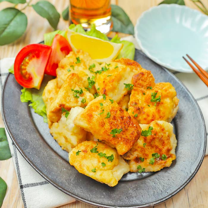 お皿に盛り付けられた料理。トマトのスライスとレモンも添えられている。