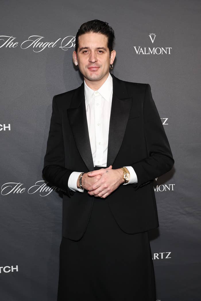 G-Eazy on the red carpet, wearing a classic tuxedo with a white shirt, posing for photos