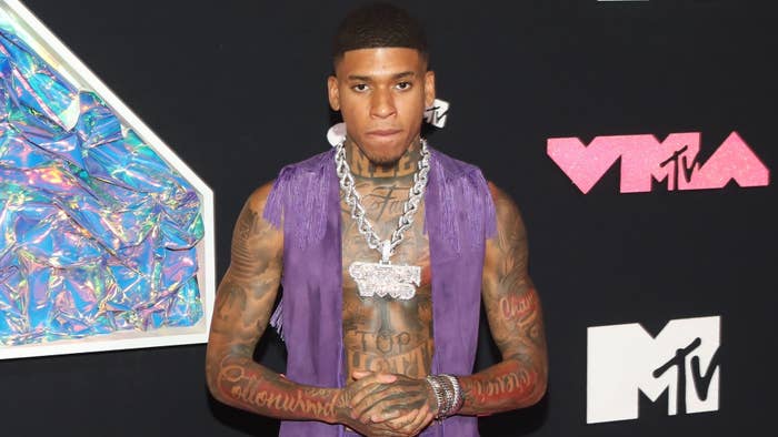 NLE Choppa on the red carpet at the MTV VMAs, wearing a purple vest and large chain necklace