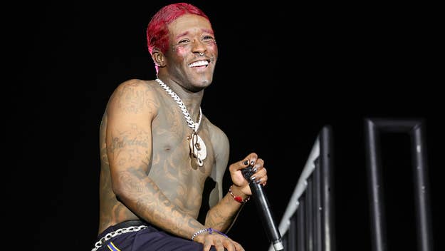 Lil Uzi Vert performing shirtless on stage, featuring tattoos and unique hairstyle, holding a microphone, wearing chains and bracelets