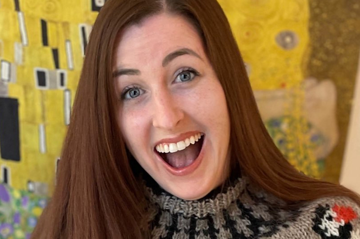 Woman smiling, wearing a knitted sweater