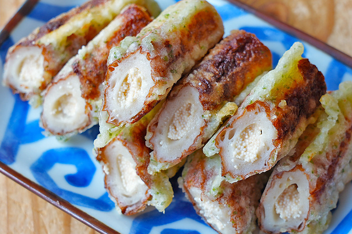 長方形の陶器皿に盛り付けられた7つの揚げたちくわが並んでいる。