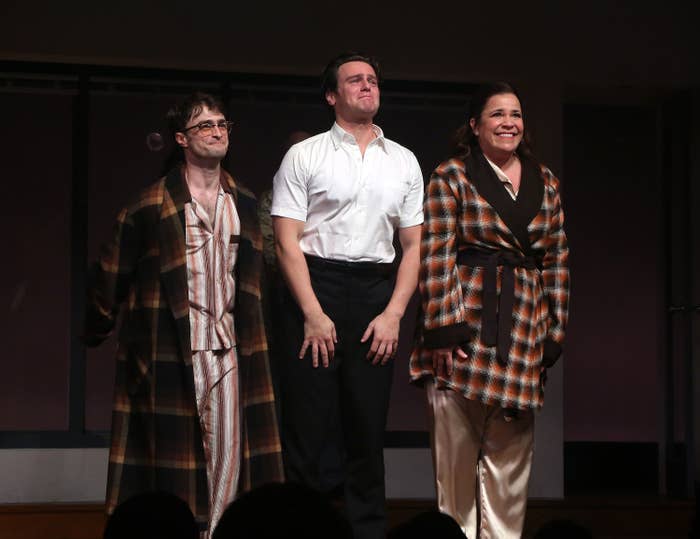 Daniel Radcliffe, Jonathan Groff, and Lindsay Mendez take a curtain call on stage, wearing a mix of casual and stage attire, after a performance